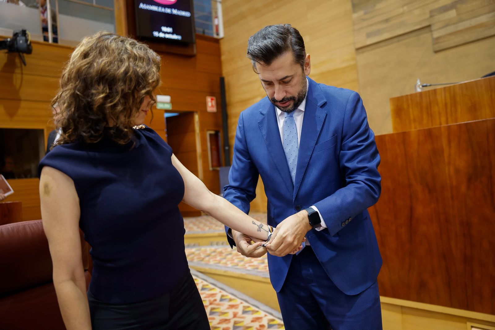 La presidenta de la Comunidad de Madrid recibe de manos del diputado popular Carlos Díaz-Pache una pulsera reivindicativa con las banderas de Ceuta y España