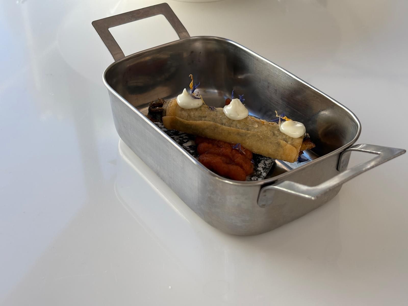 La tapa ganadora: boquerón sobre una regaña de carbón negro envuelto en pasta filo y acompañado de confitura de tomate, acompañado de mayonesa de lima.