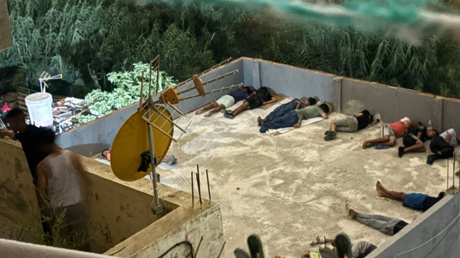 Inmigrantes durmiendo en la azotea de una casa de la barriada La Sanidad, donde se colaron en la noche del jueves