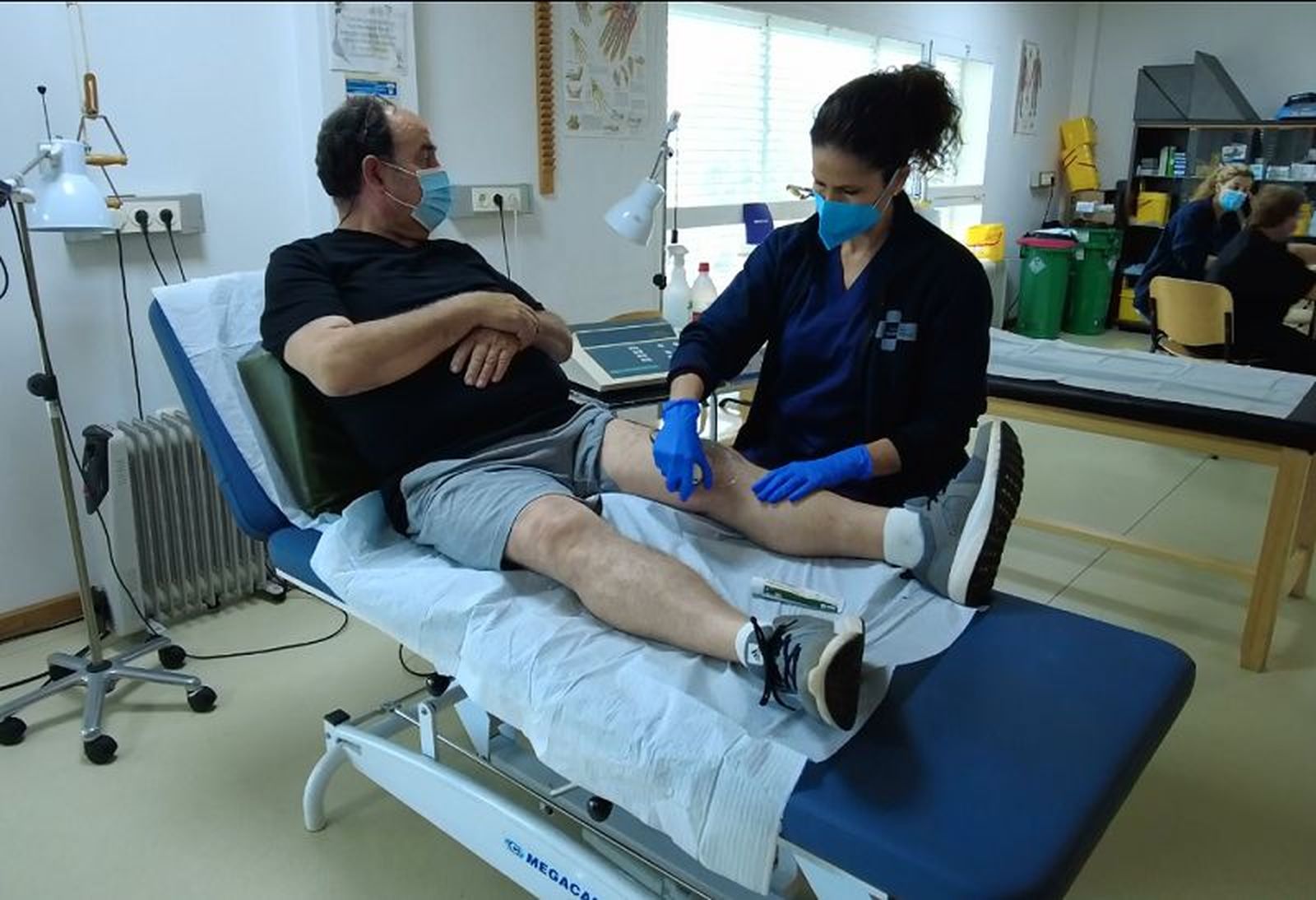 Una fisioterapeuta atiende a un paciente