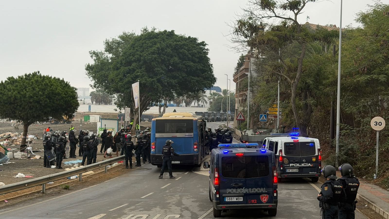 La Policía Nacional escolta los autobuses llenos de migrantes hacia el Tarajal desde el Trampolín