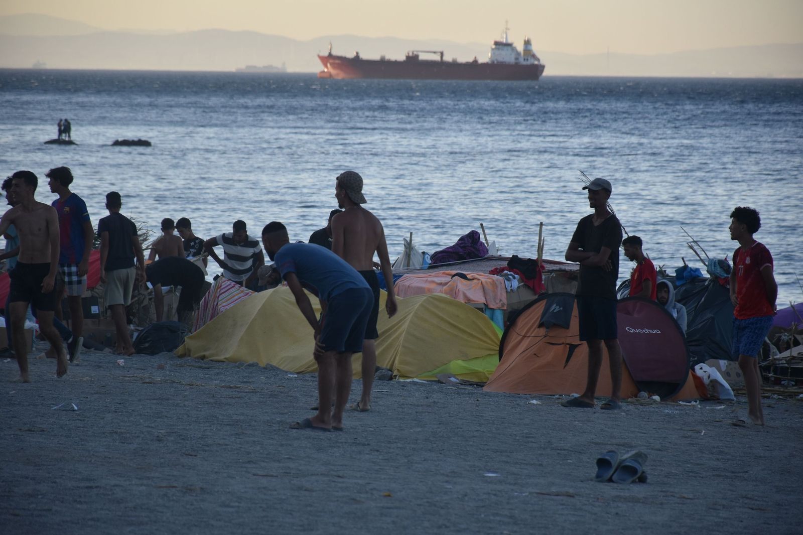 Migrantes juegan al fútbol en la playa del Trampolín