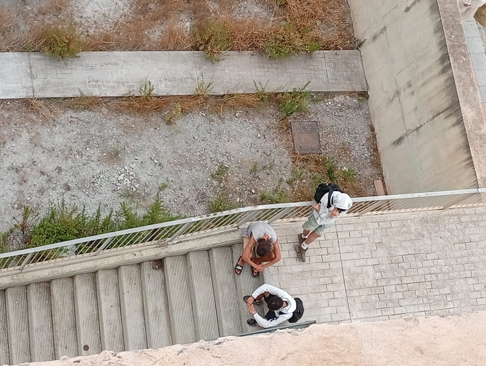 Migrantes acechando la entrada de un edificio en Loma Colmenar