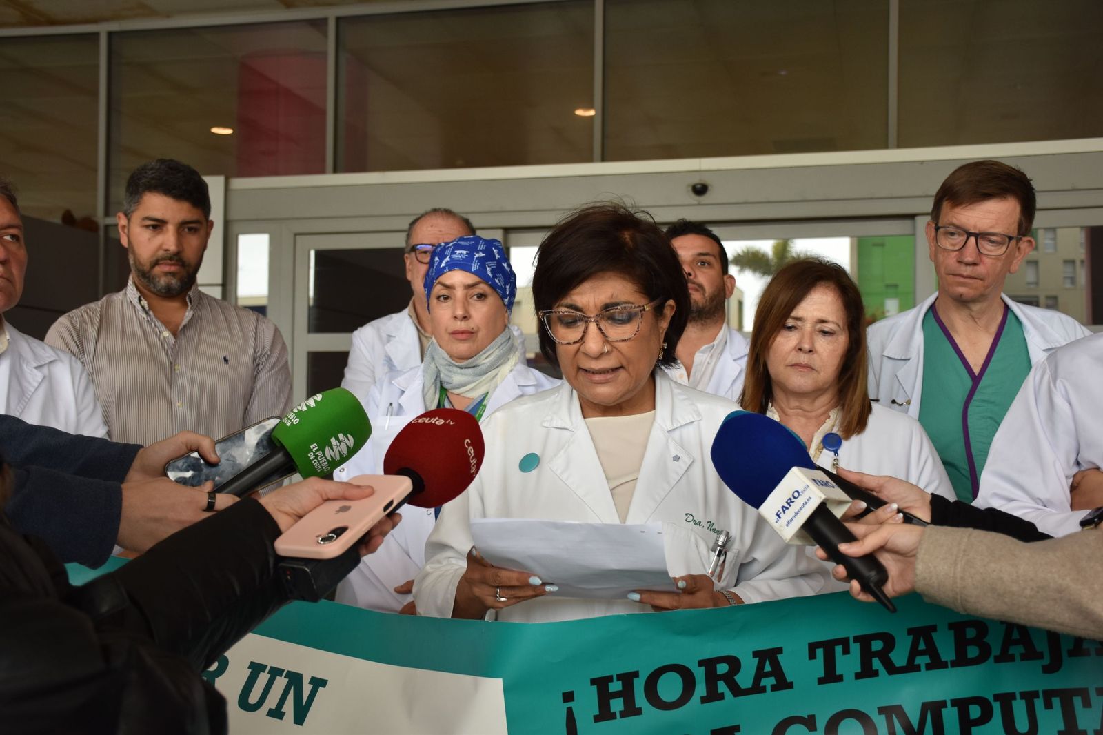 La delegada de MUD en Ceuta, Kumari Nanwani, lee un manifiesto por la huelga de médicos durante la concentración en el HUCE