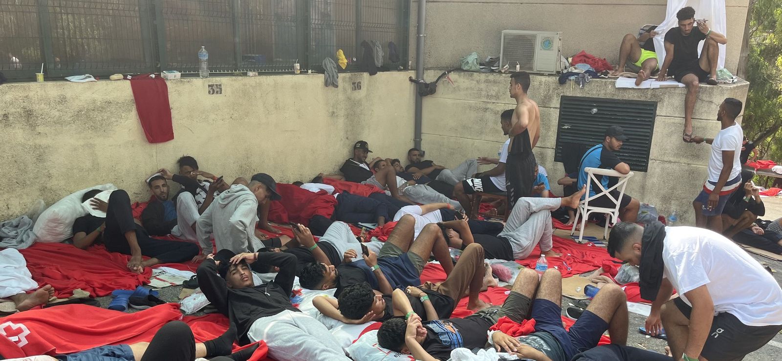 Personas migrantes esperando a las puertas del CETI su ingreso en las instalaciones