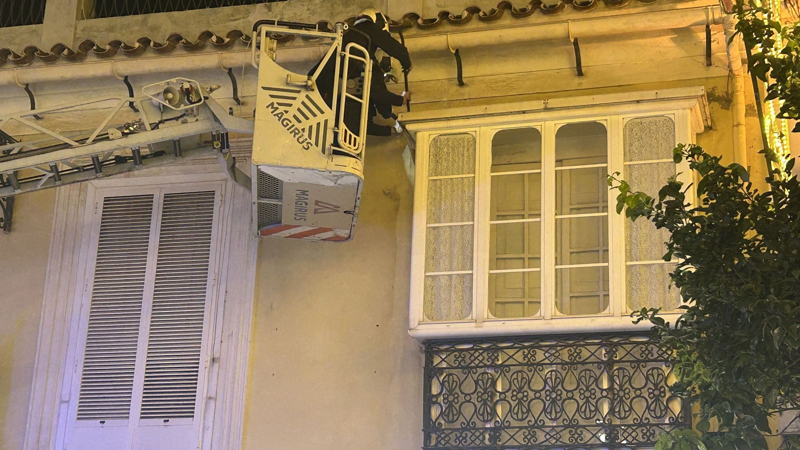 Bomberos controlando un vertido de agua desde el techo de una ventana salediza en el Revellín