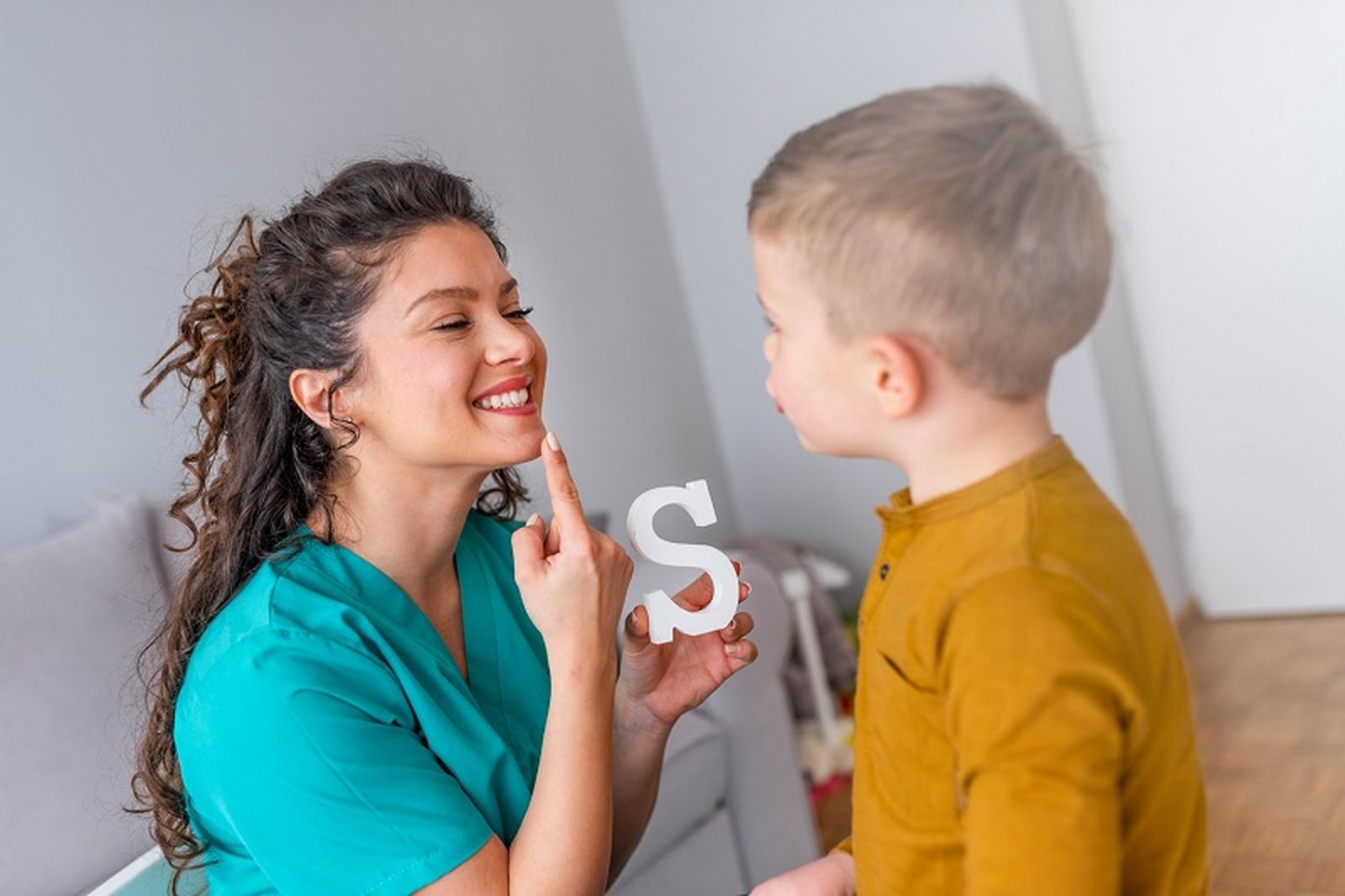 Una logopeda junto a un niño
