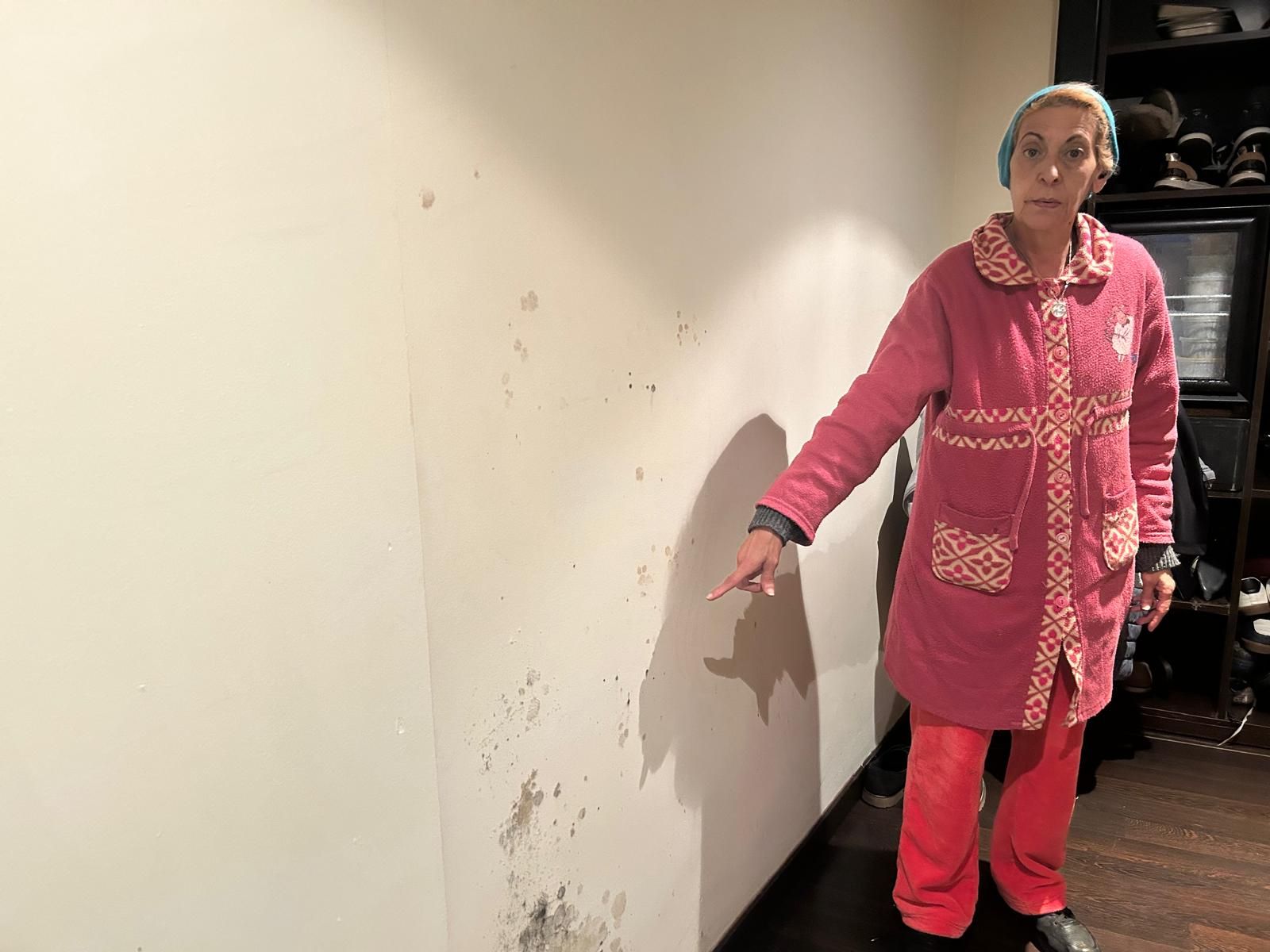 Hanan Habib muestra las humedades de la habitación donde está alojada en el Hotel Puerta de África