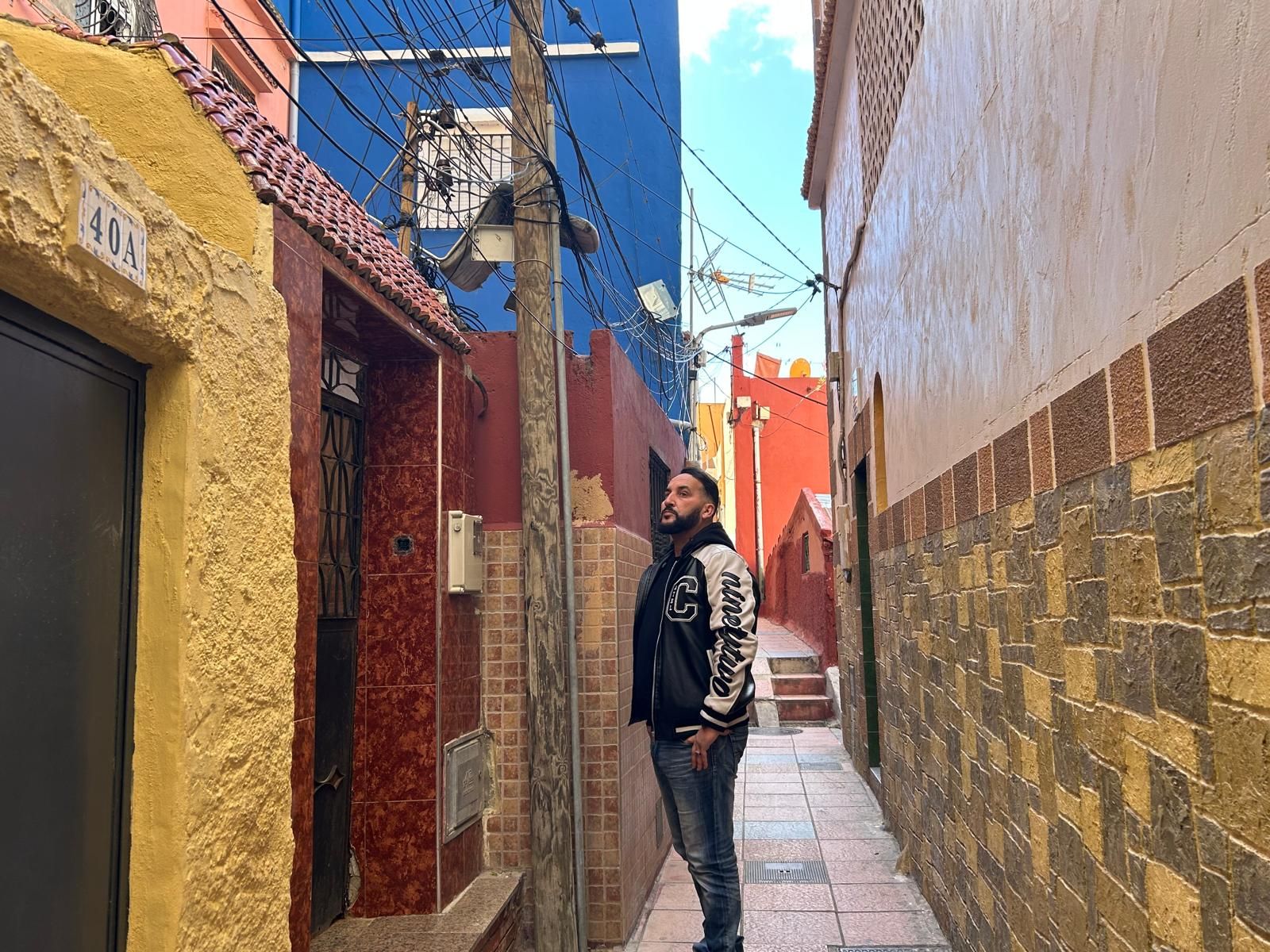 El presidente de la Asociación de Vecinos de Pasaje Recreo, Abdelmalik Mohamed Amar, frente a un poste con cableado aéreo