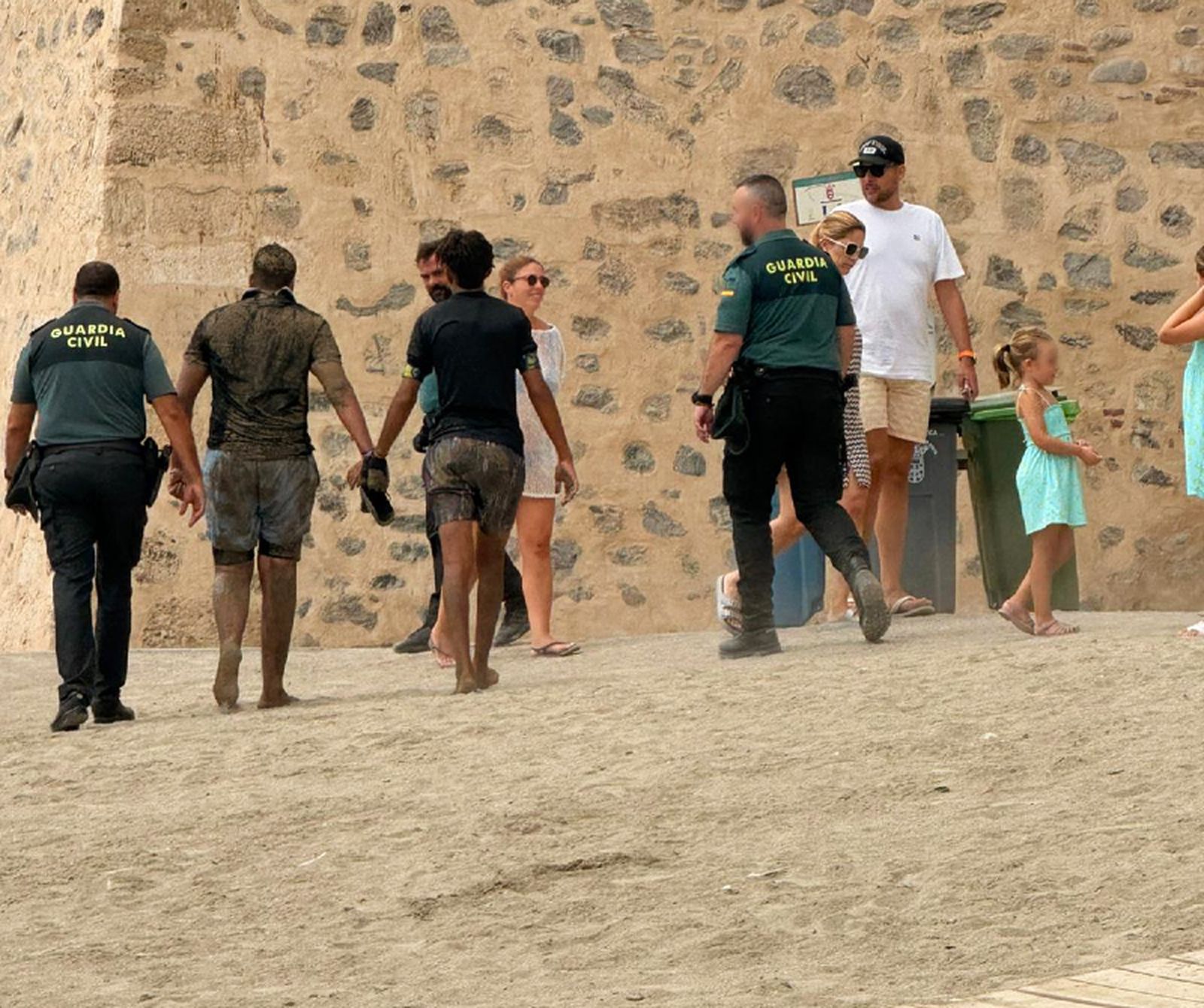 Los jóvenes, acompañados de la Guardia Civil, abandonan la playa / Cedida