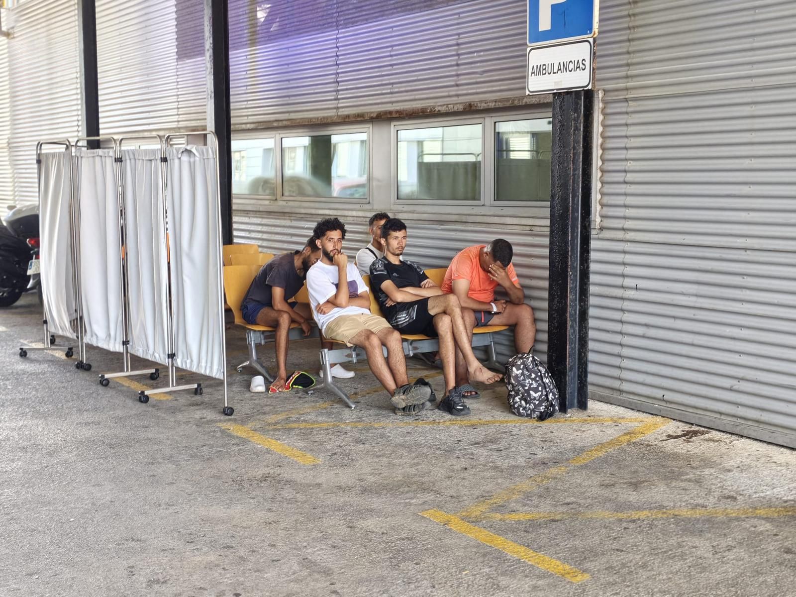 Migrantes esperan a las puertas del Servicio de Urgencias del HUCE este martes