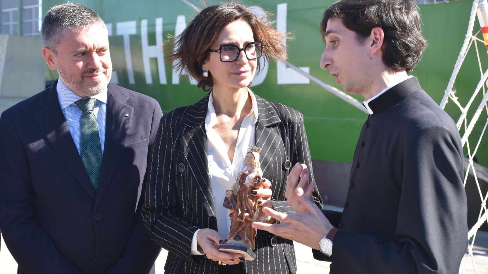 Un sacerdote ofrece a Emanuela Franchini, de Fratelli Cosulich, la imagen de la virgen del Carmen que protegerá la gabarra