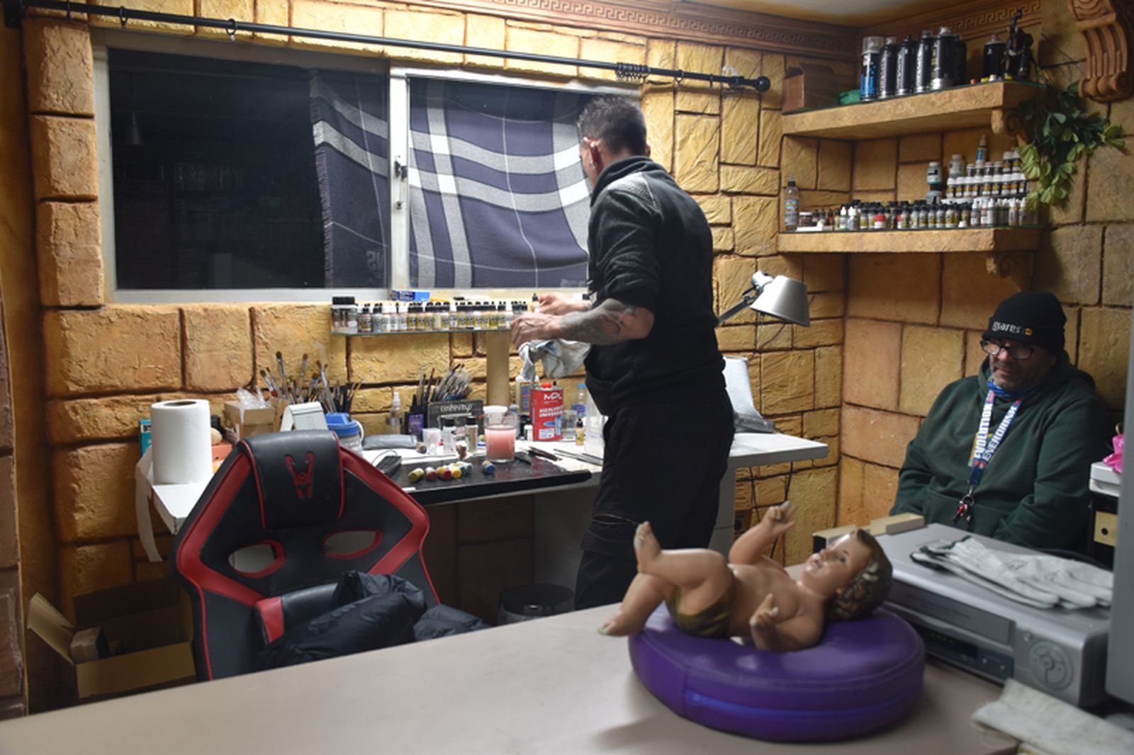 Dos compañeros de Lorda trabajan en su taller, donde ese día restauraban un niño de Dios. / FOTO G.S.