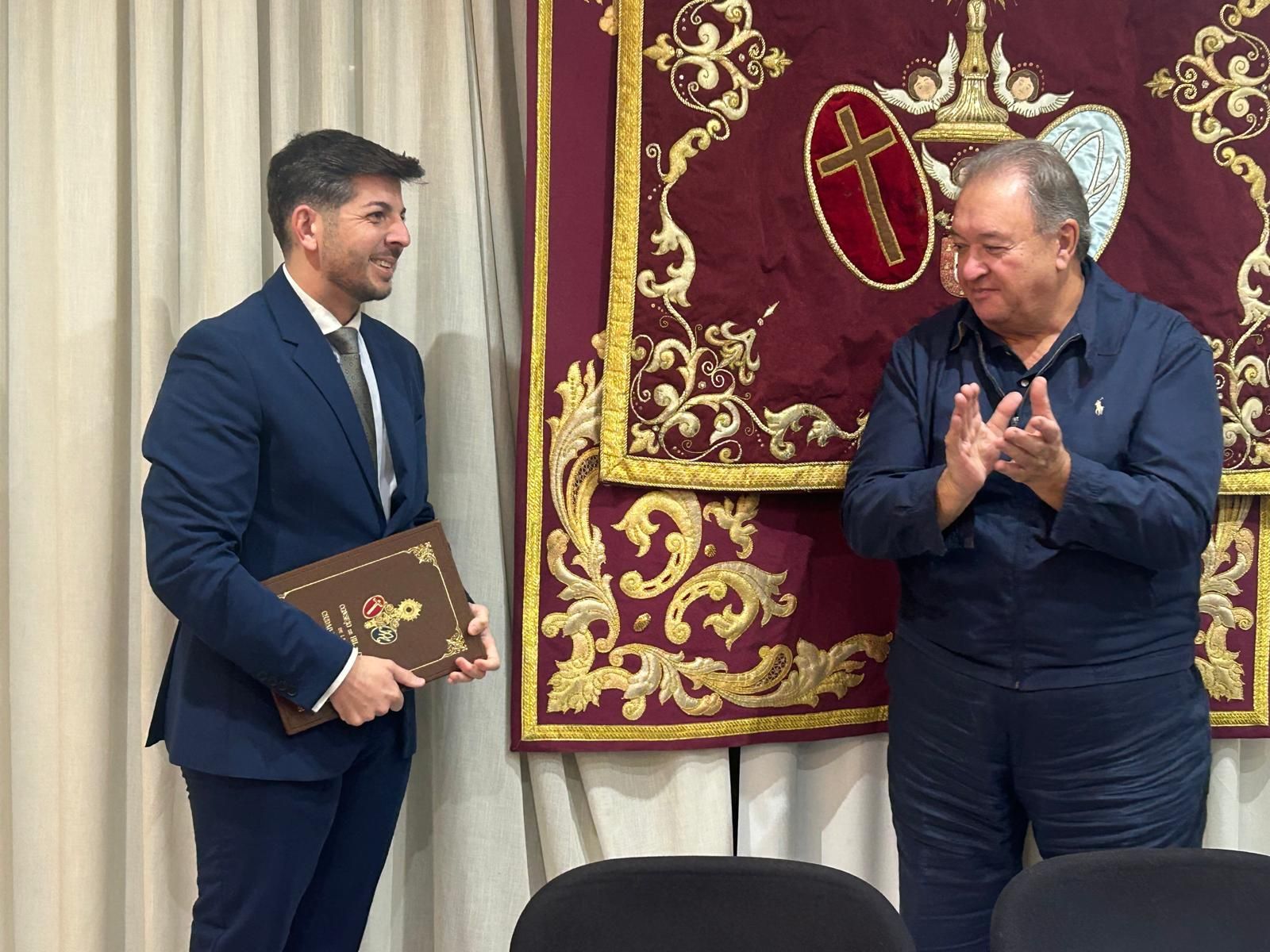 Adán del Campo recibe las guardas para el pregón de la Semana Santa 2026 de manos del presidente del Consejo de Hermandades, Jesús Bollit