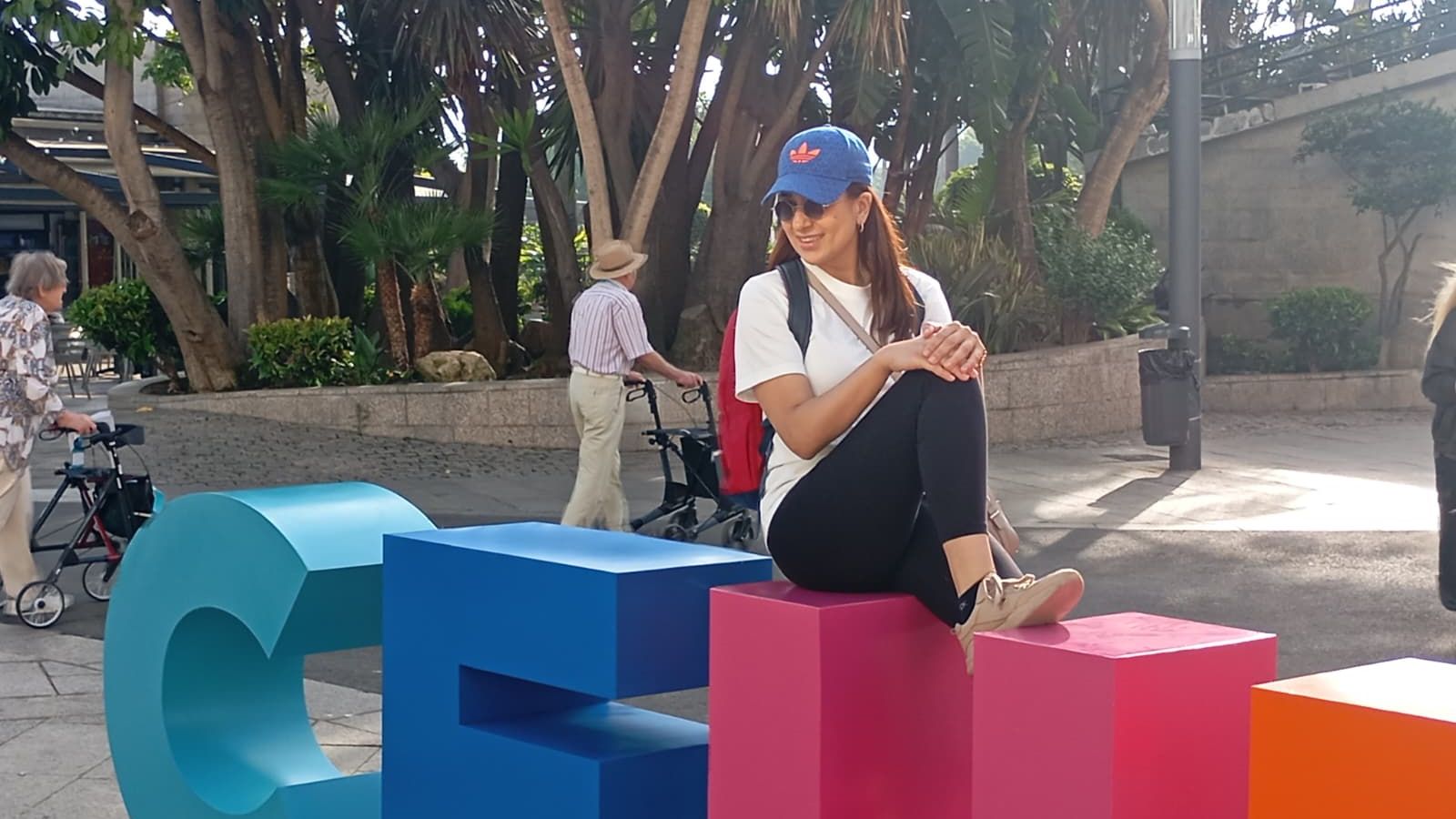 Una crucerista se hace una fotografía sobre las letras que forman el nombre de la ciudad