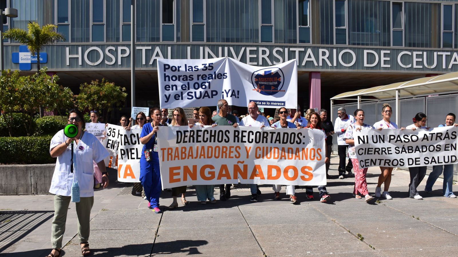 La delegada de SATSE, Elisabeth Muñoz, habla a través del megáfono al centenar de profesionales de INGESA concentrados en el hospital contra la aplicación de INGESA de la jornada de 35 horas