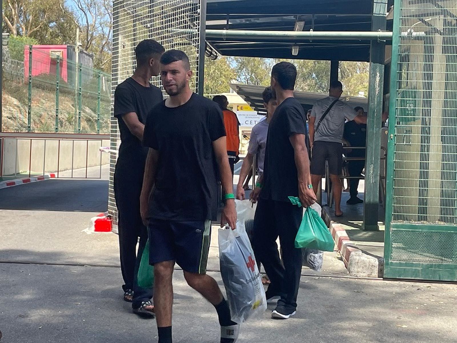 Residentes recién llegados al CETI acarrean bolsas con ropa y comida. / FOTO REDUAN