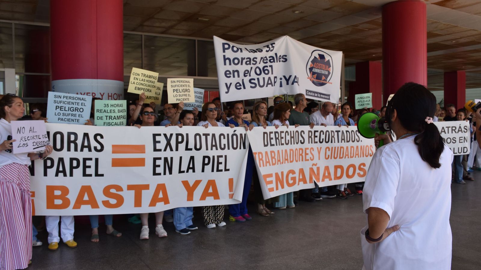 La delegada de SATSE, Elisabeth Muñoz, habla a través del megáfono al centenar de profesionales de INGESA concentrados en el hospital contra la aplicación de INGESA de la jornada de 35 horas