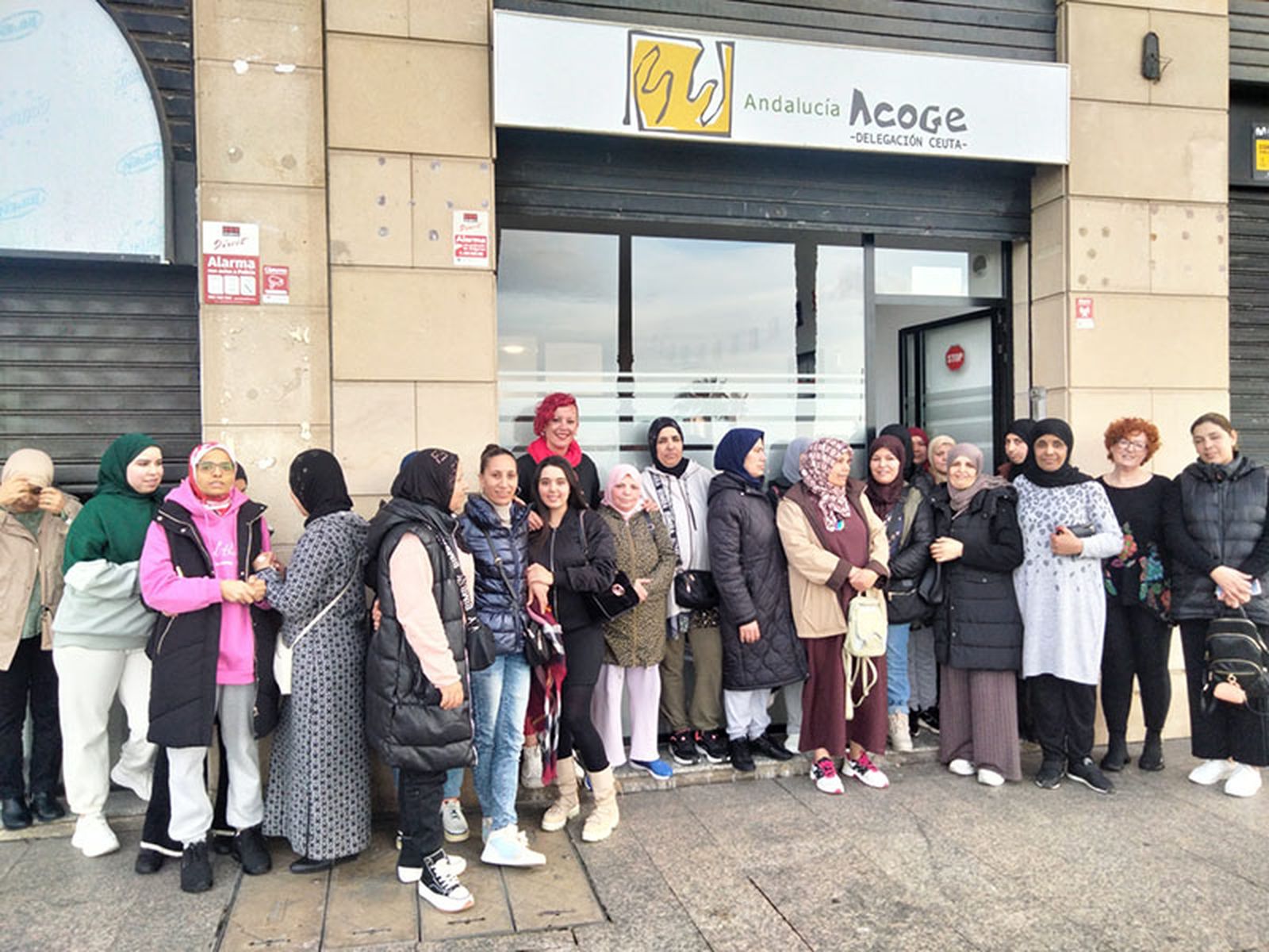 Participantes en las actividades de Andalucía Acoge, ante la puerta de la sede/FOTO CEDIDA