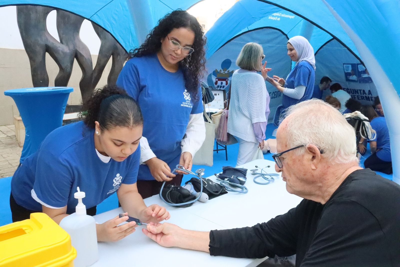 Dos enfermeras atienden a un señor durante la joranda informativa organizada por el Colegio de Enfermería este miércoles