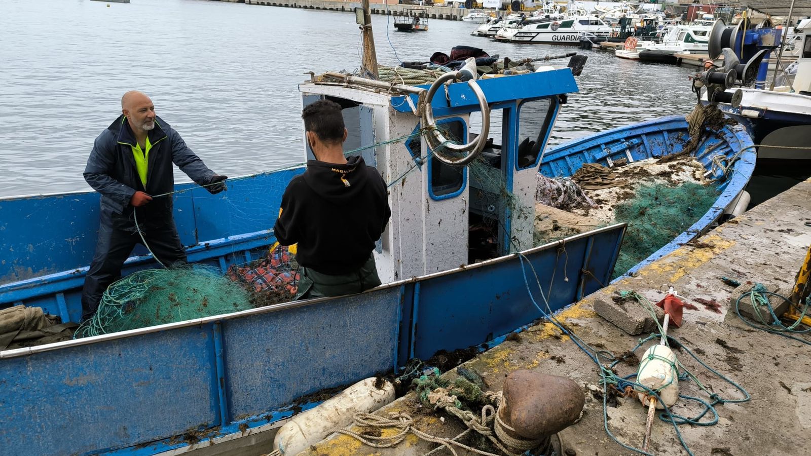 Dos pescadores limpiando unas redes en la lonja de Ceuta en una imagen de archivo.