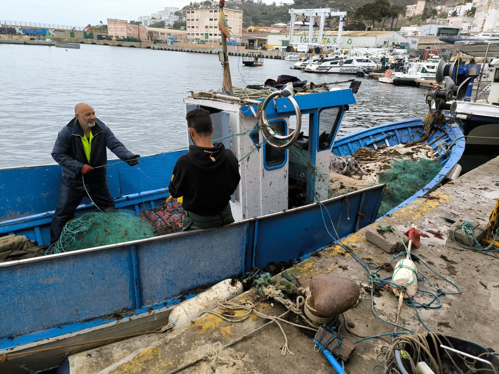 Dos pescadores limpiando unas redes en la lonja de Ceuta en una imagen de archivo.