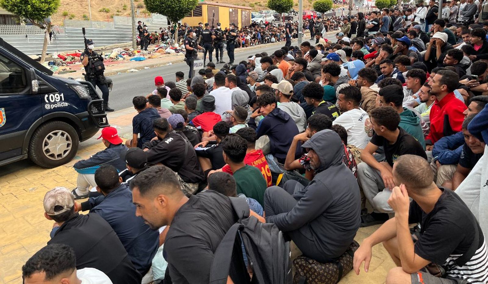 Inmigrantes frente a explanada de embotellamiento Loma Colmenar.