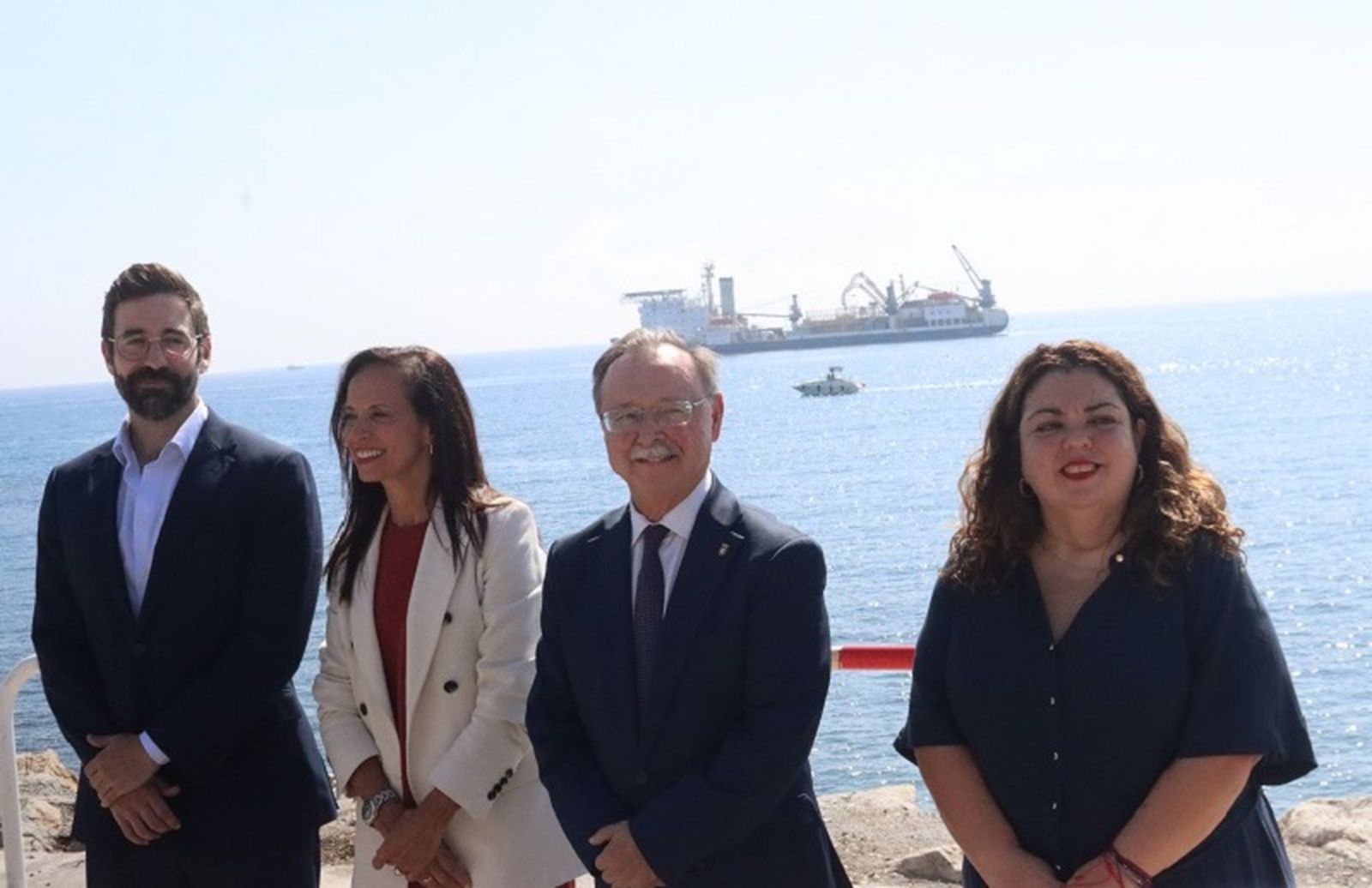 El secretario de Estado de Energía, Joan Groizard, la presidenta de Redeia, Beatriz Corredero, el presidente de Ceuta, Juan Vivas, y la delegada, Cristina Pérez, con el barco que ha transportado el cable submarino de fondo