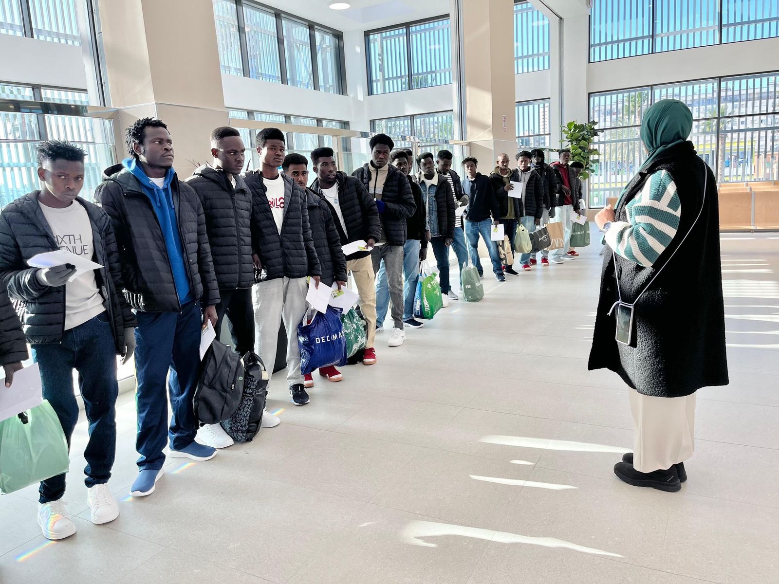 Un grupo de migrantes espera para pasar el control policial en la Estación Marítima de Ceuta este jueves