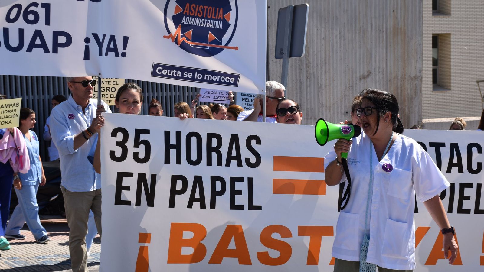 La delegada de SATSE, Elisabeth Muñoz, habla a través del megáfono al centenar de profesionales de INGESA concentrados en el hospital contra la aplicación de INGESA de la jornada de 35 horas
