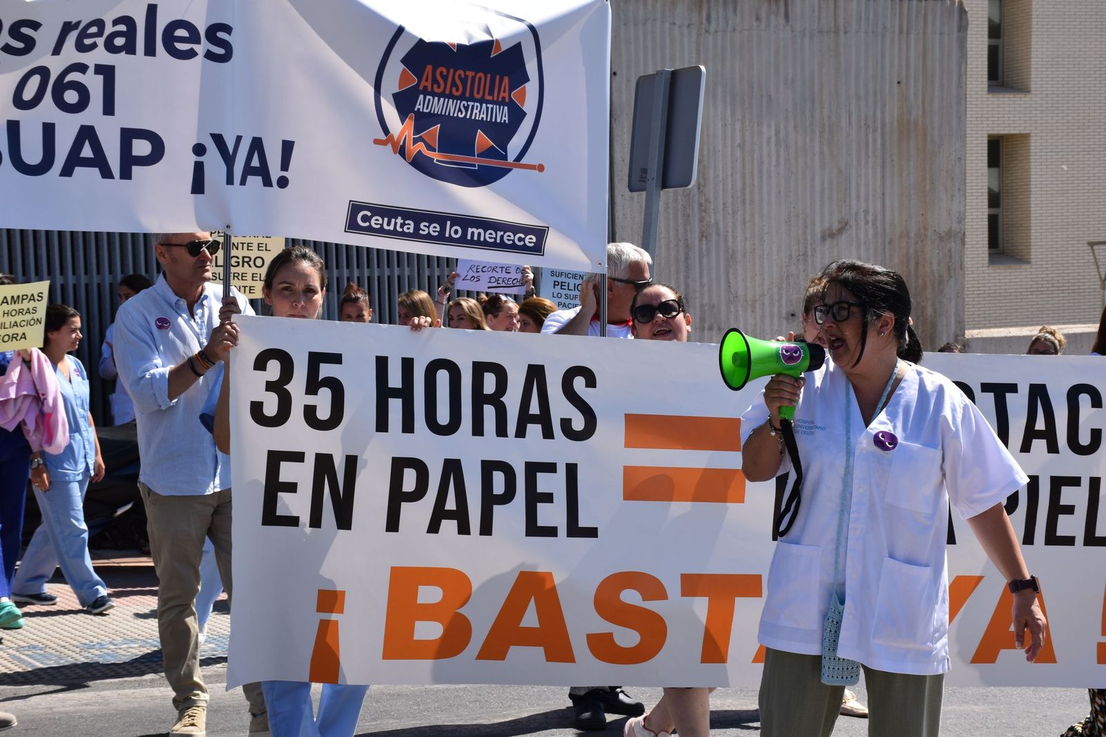 La delegada de SATSE, Elisabeth Muñoz, habla a través del megáfono al centenar de profesionales de INGESA concentrados en el hospital contra la aplicación de INGESA de la jornada de 35 horas