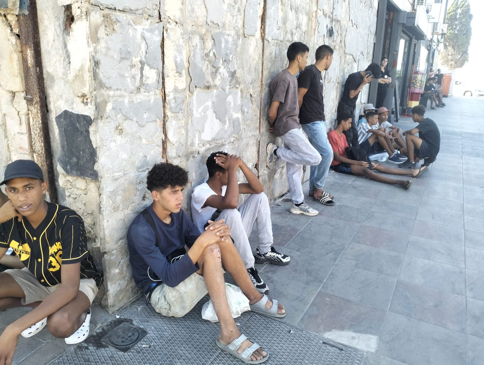 Varios migrantes sentados a las puertas del Ceuta Center