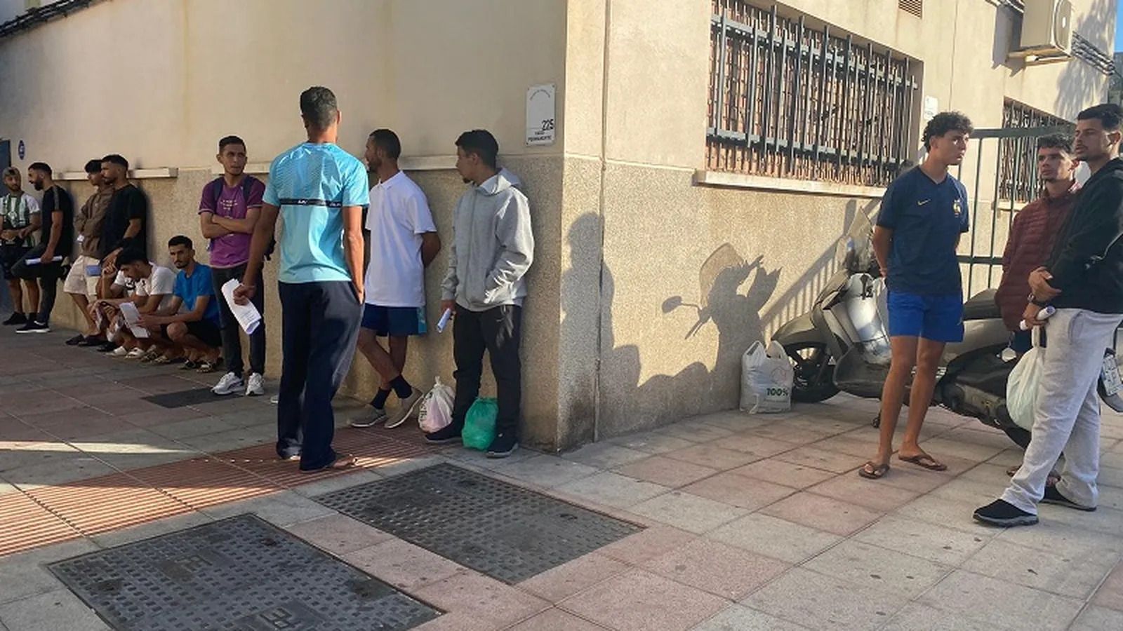 Varias personas migrantes aguardan a las puertas de la Jefatura de la Policía Nacional en una foto de archivo