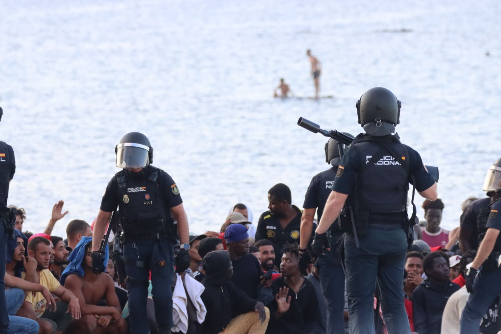 Migrantes en la playa del Trampolín, controlados por la Policía Nacional