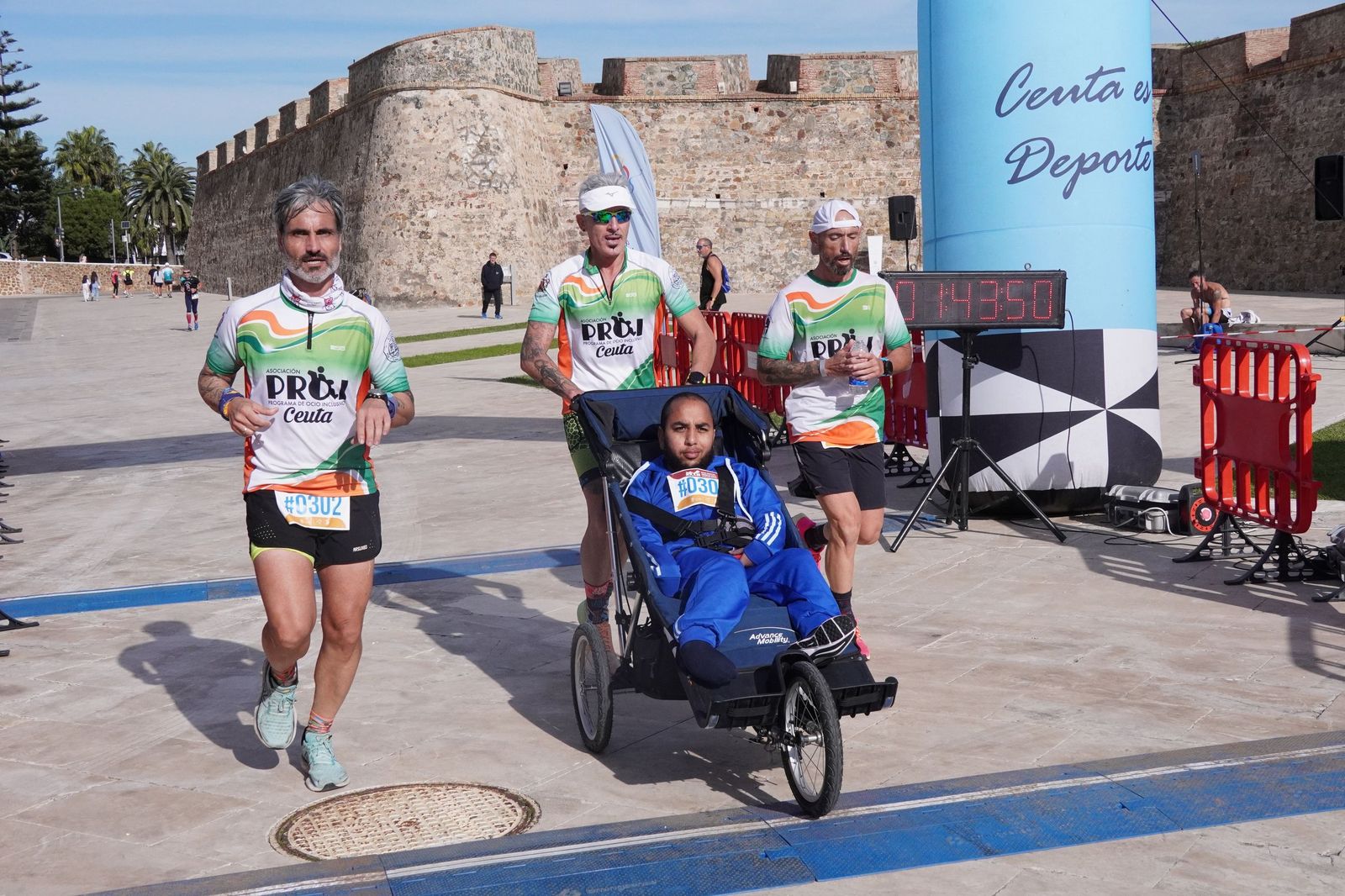 Corredor de PROI con su impulsor voluntario durante la Media Maratón de este domingo