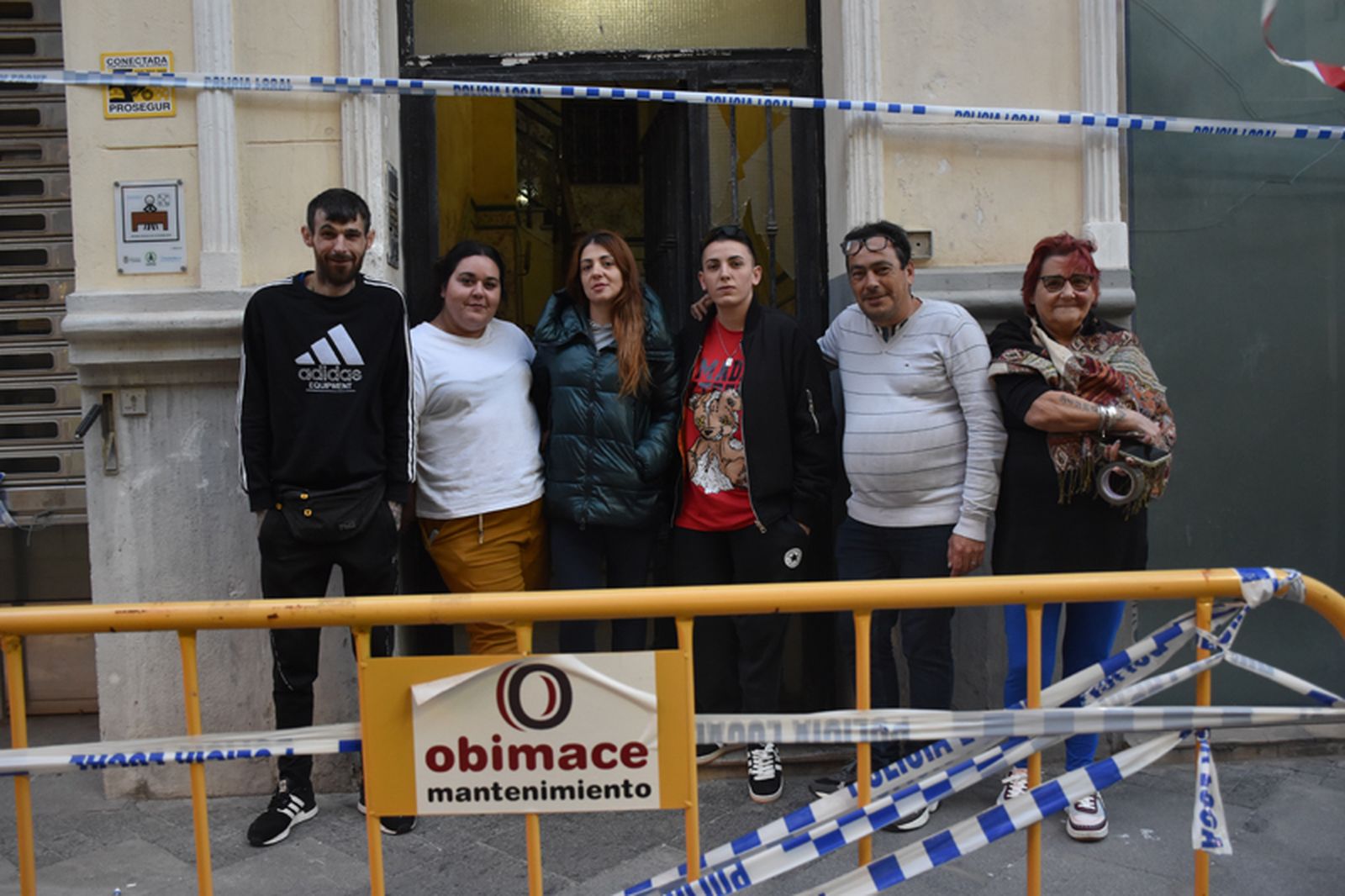 Varios vecinos del número 4 de González de la Vega posan a las puertas del edificio, ya acordonado por la declaración de ruina técnica. / FOTO G.S.
