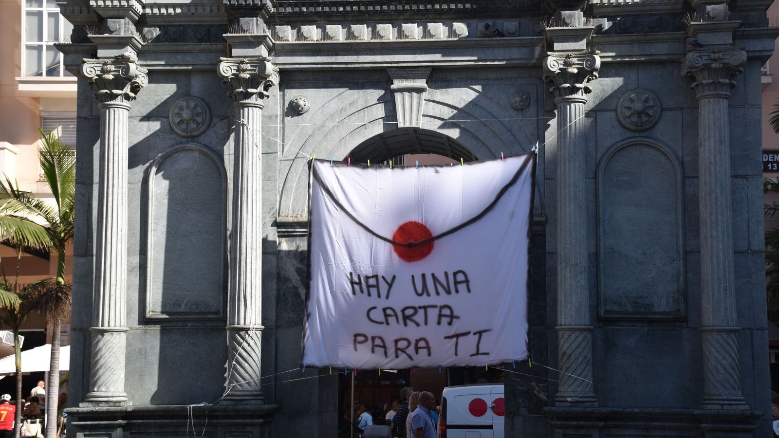 Una pancarta simulando un sobre lacrado cuelga de la antigua puerta del hospital frente a Delegación del Gobierno