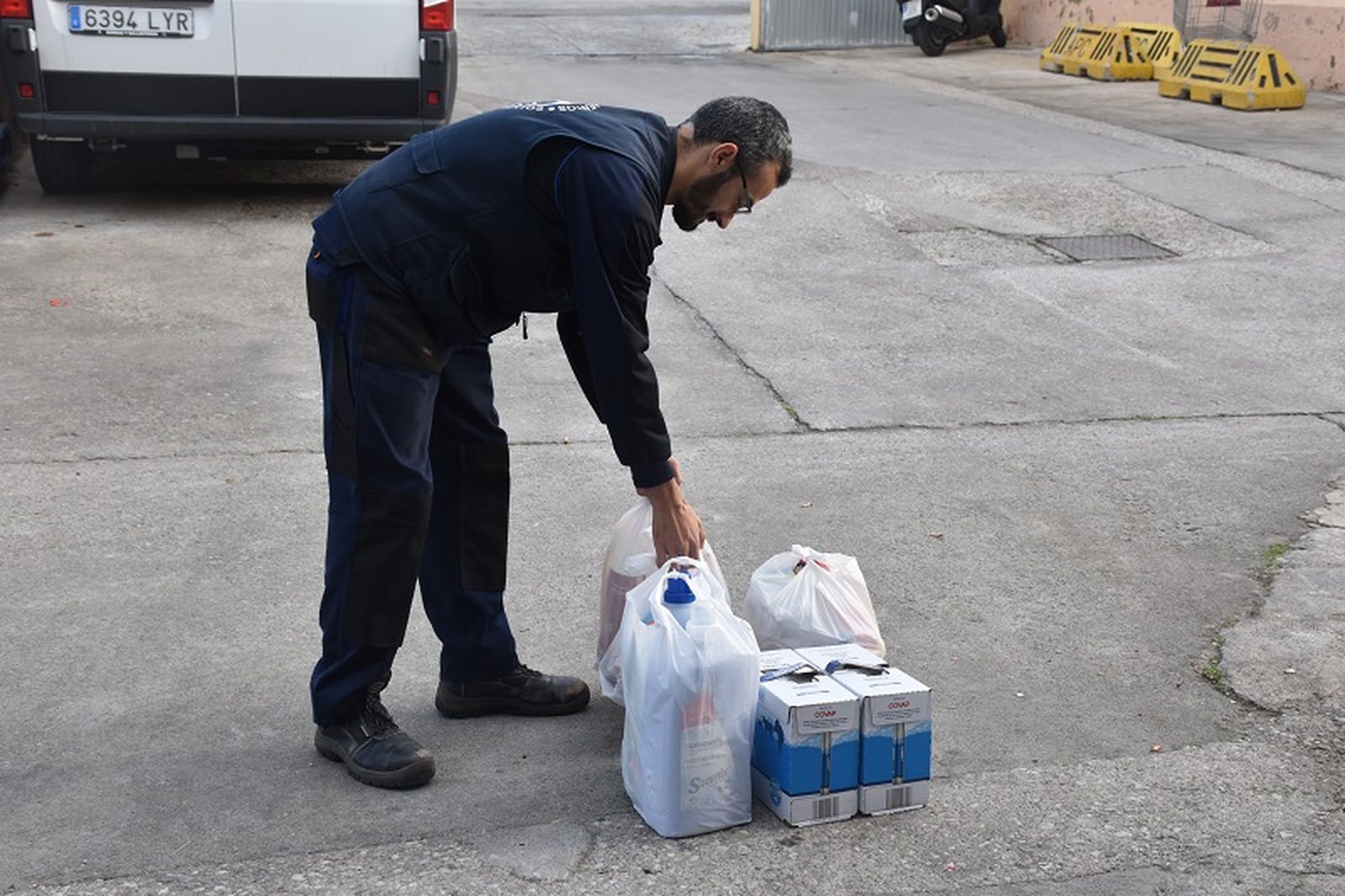 Raúl García, trabajador del Banco de Alimentos desde hace dos años, deposita sobre el suelo los alimentos destinados a una de las familias beneficiarias. / FOTO G.S.