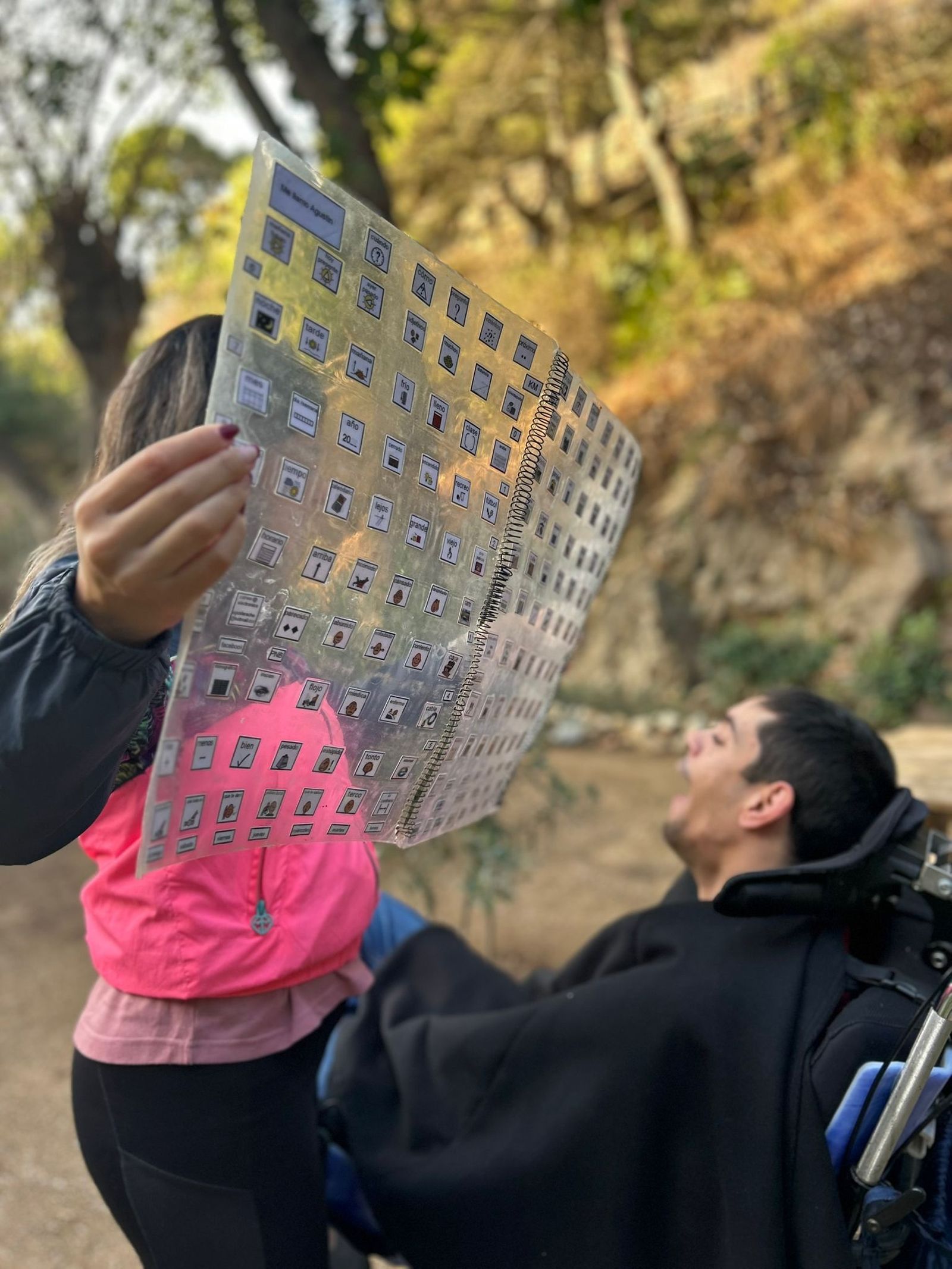 Una activista de PROI sostiene un pliego con pictogramas ante un usuario de la asociación