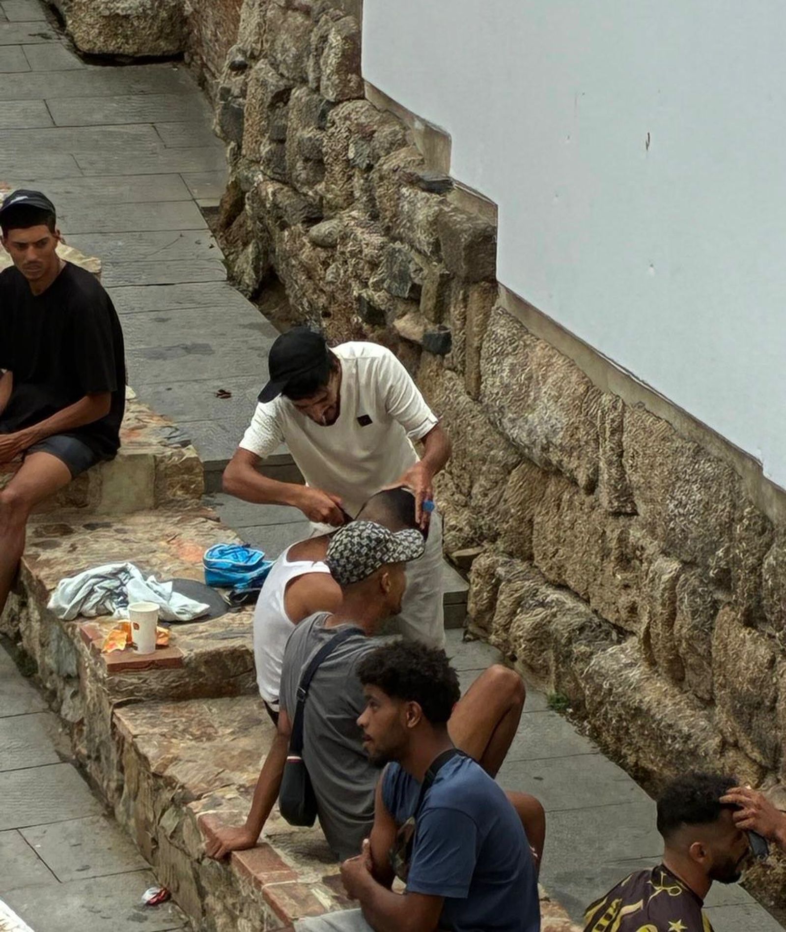 Peluquería marroquí en plena vía pública junto a la Basílica Tardorromana, sin higiene ni condiciones sanitarias