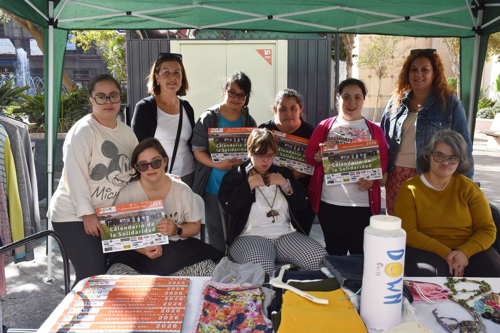 Miembros y usuarias de la Asociación Síndrome de Down posan con el calendario solidario en el stand instalado este miércoles en la plaza de los Reyes