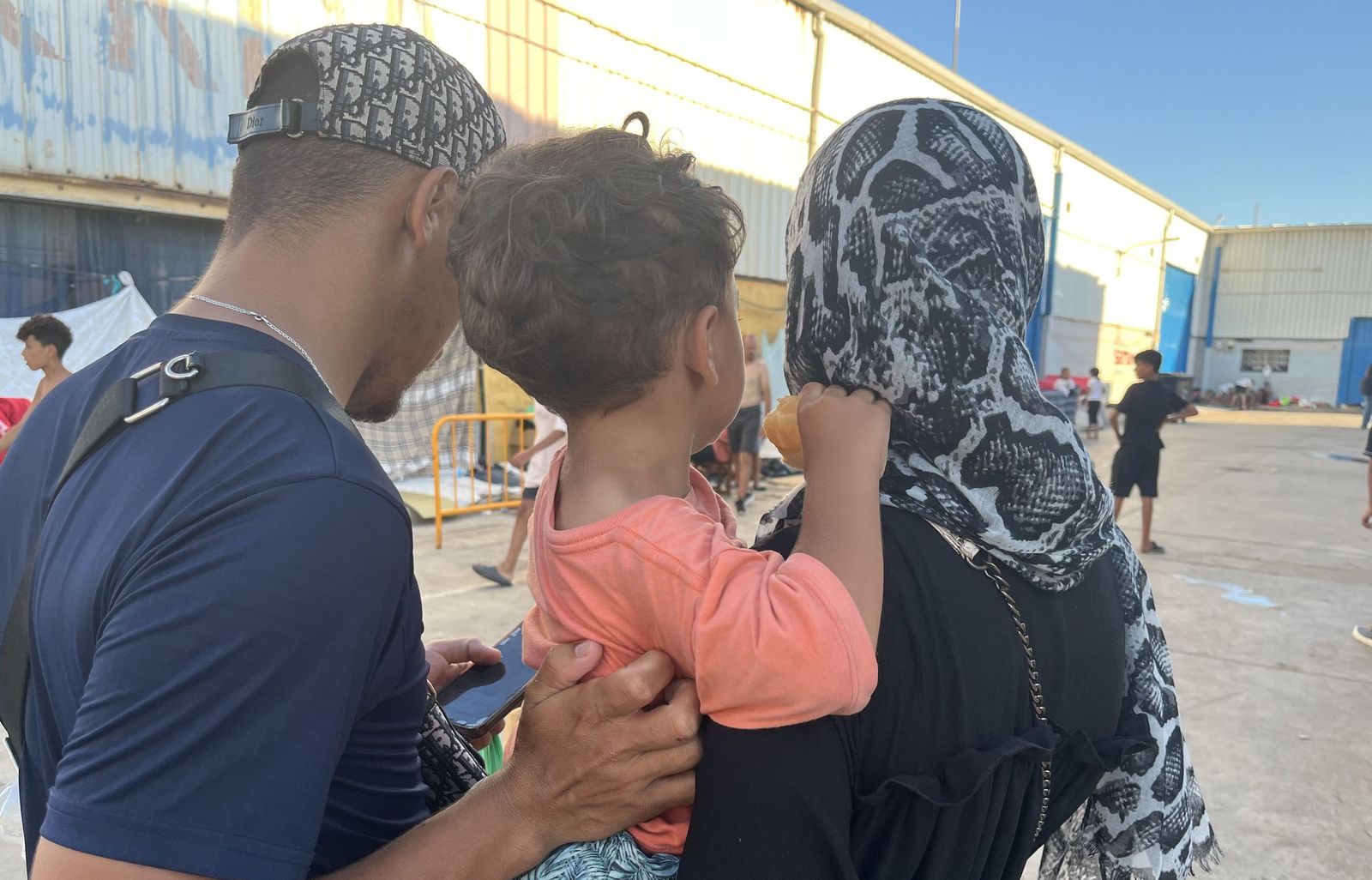 La familia marroquí formada por Amin, Salma y Amjad posan de espaldas en el Polígono del Tarajal, donde viven desde la entrada masiva