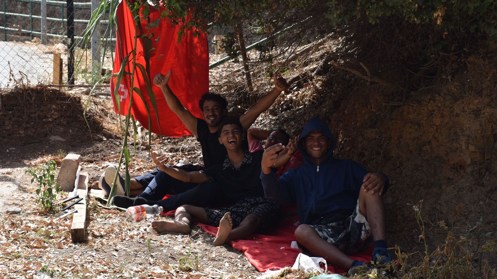 Migrantes en las inmediaciones del CETI a la espera de ingresar en las instalaciones, este jueves