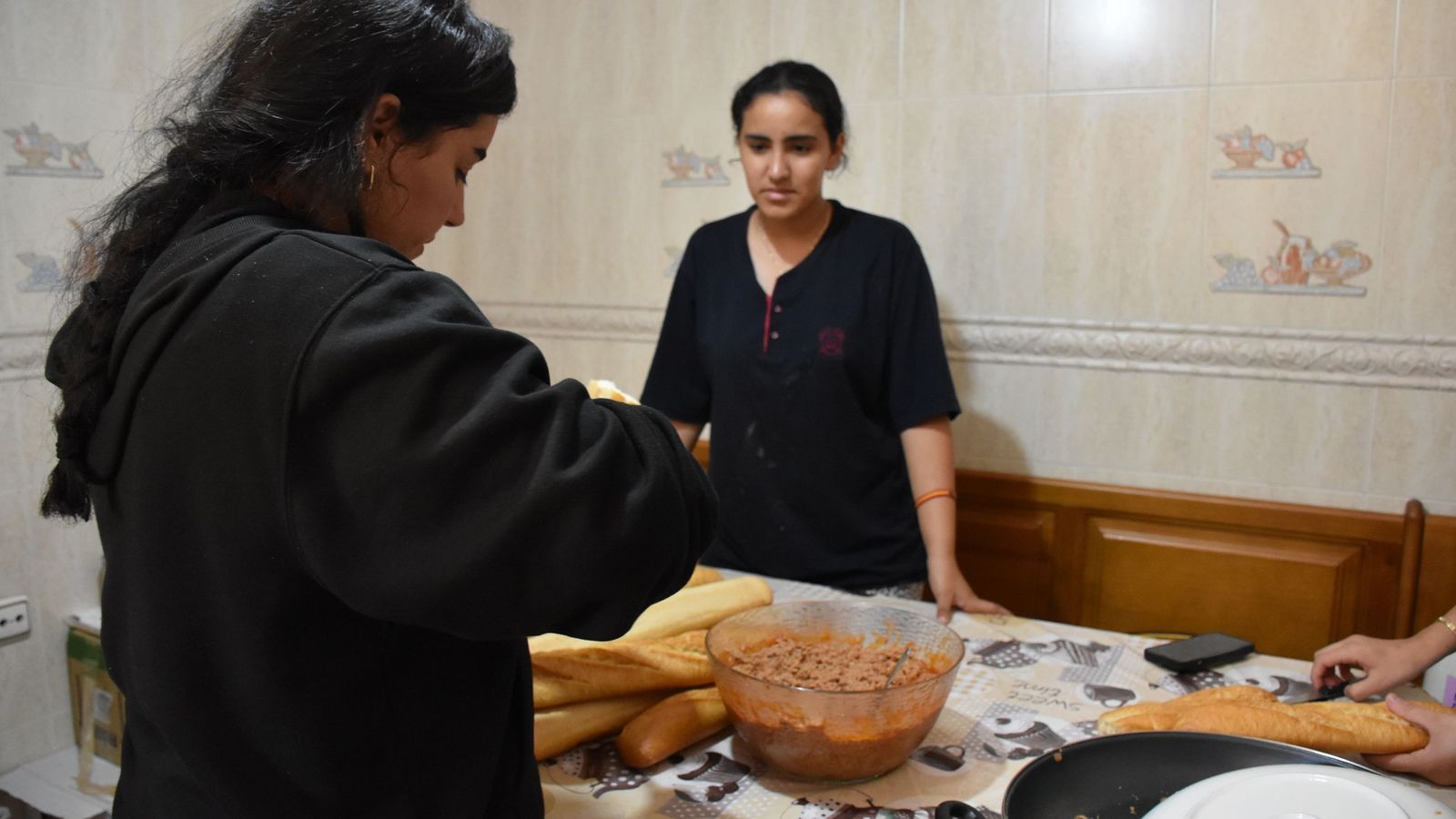 Dos voluntarias preparan bocadillos de atún para los migrantes en la casa de Hanan Ahmed