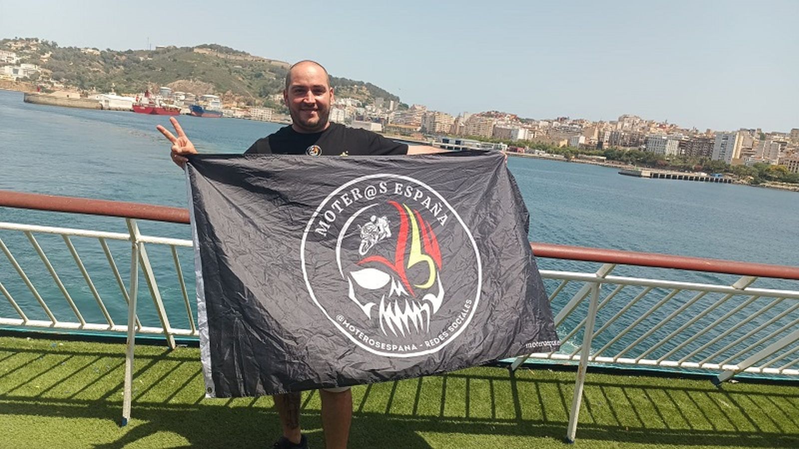 El abanderado de Ceuta, Toni, sostiene la bandera en el barco de Algeciras a la ciudad. / FOTO CEDIDA