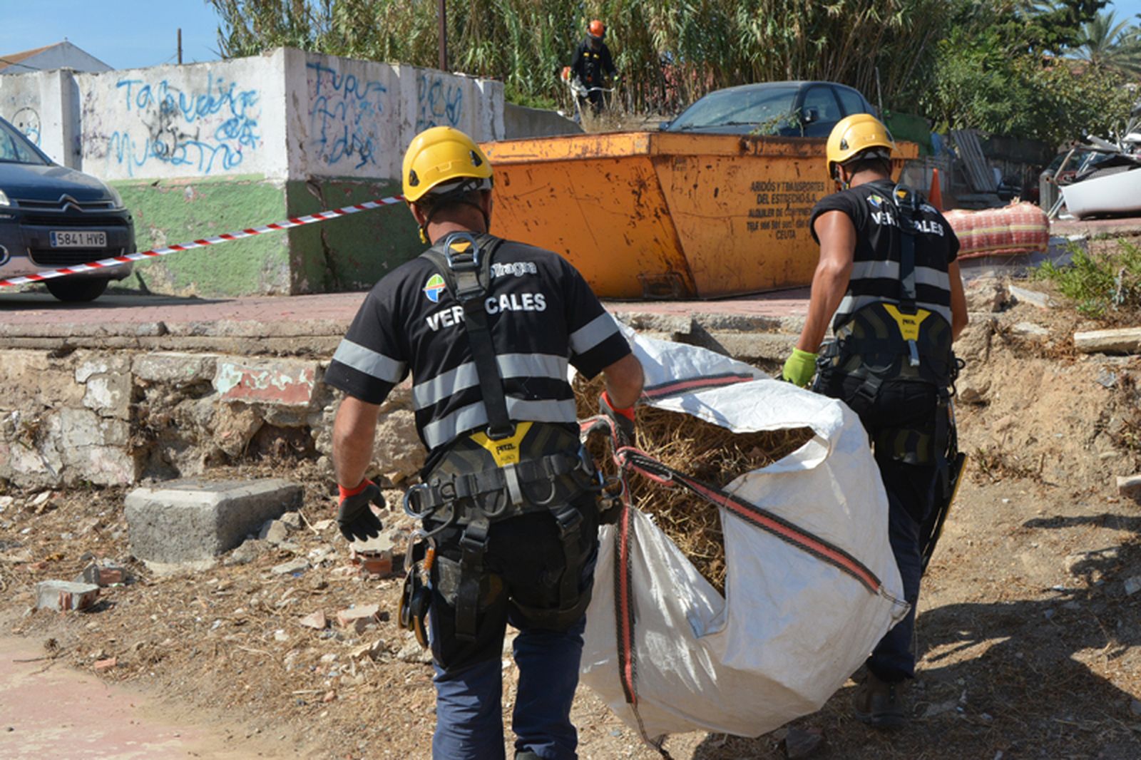 Bilal y Ali con rastrojos recogidos antes de descargarlos en el contenedor. / FOTO J.I.M.