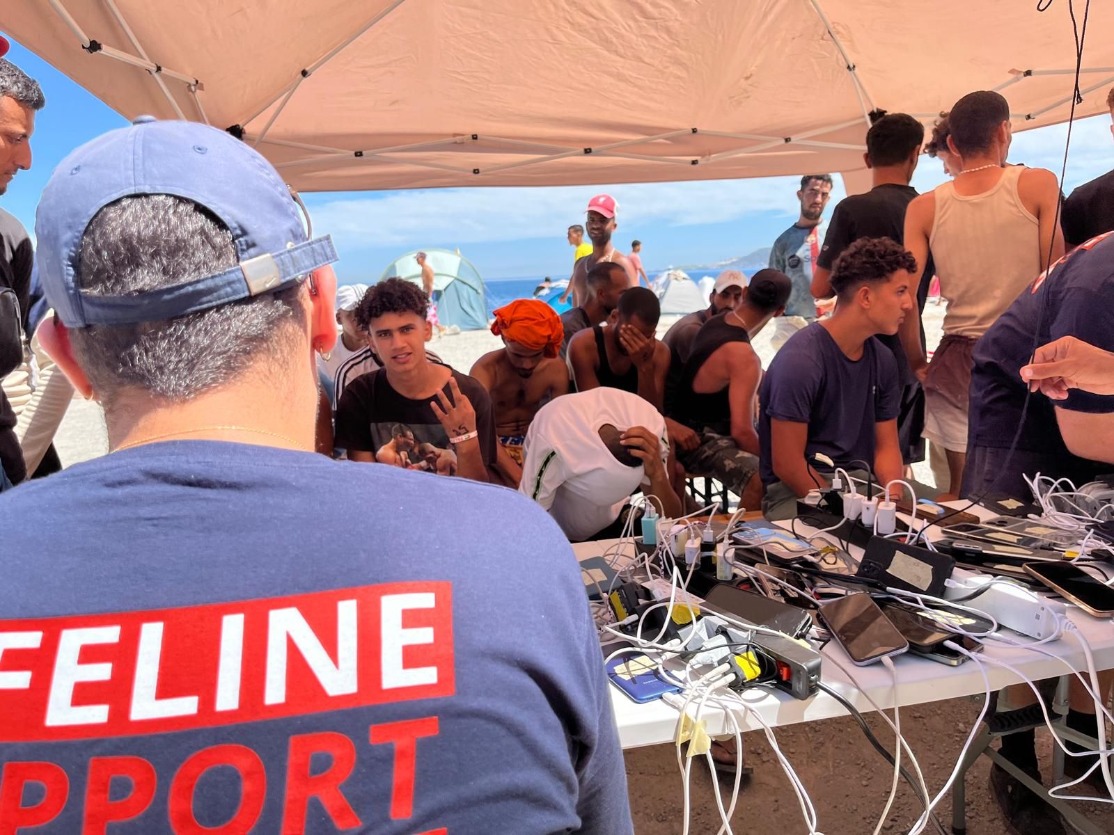 Un voluntario de la ONG alemana supervisa la carga de móviles de los migrantes del Trampolín