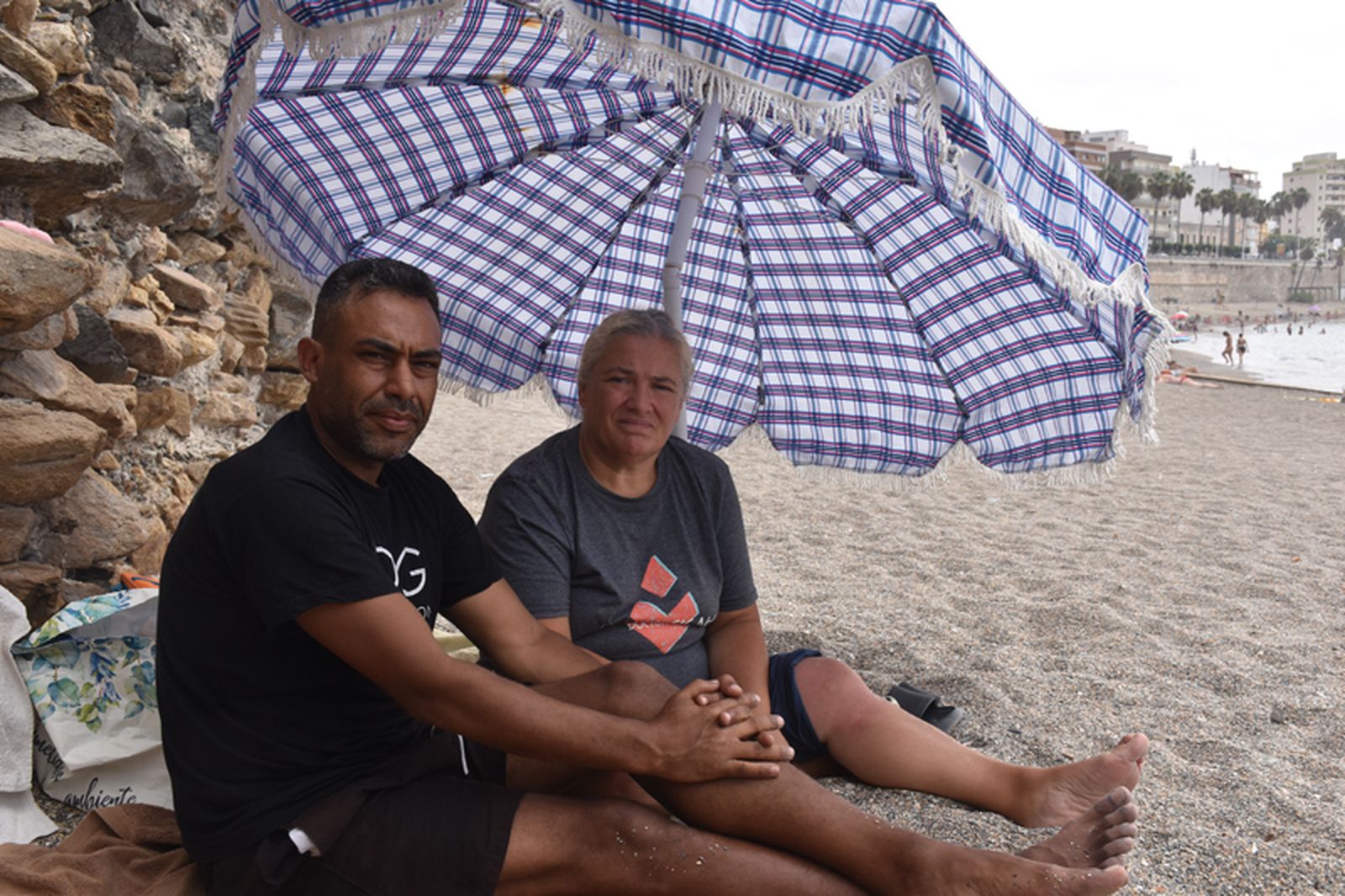Mónica y Tayeb posan en su asentamiento en la playa de la Ribera, donde duermen desde el 21 de julio