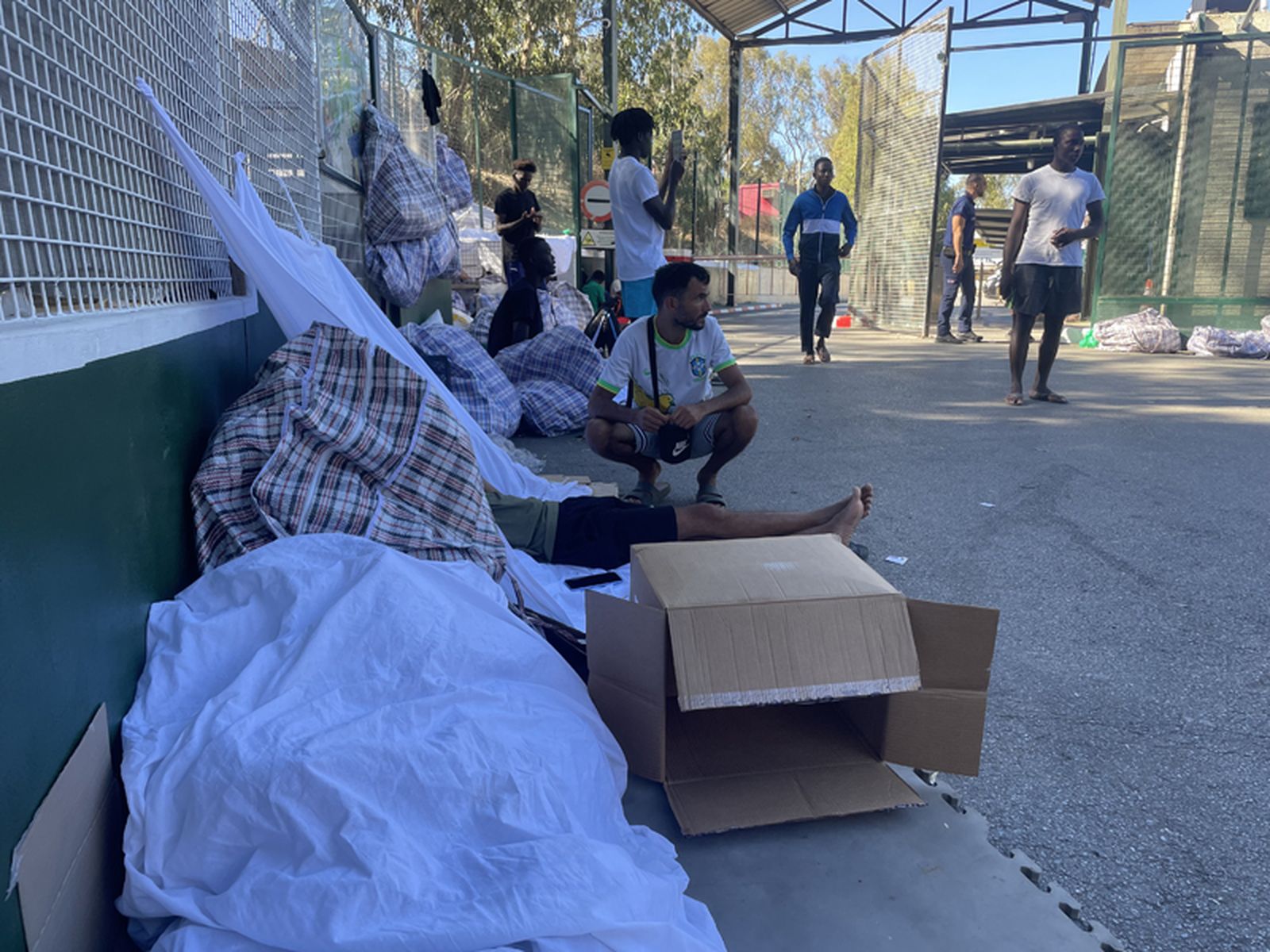 Varias personas aguardan a las puertas del CETI su entrada como residentes en las instalaciones, este miércoles. / FOTO REDUAN