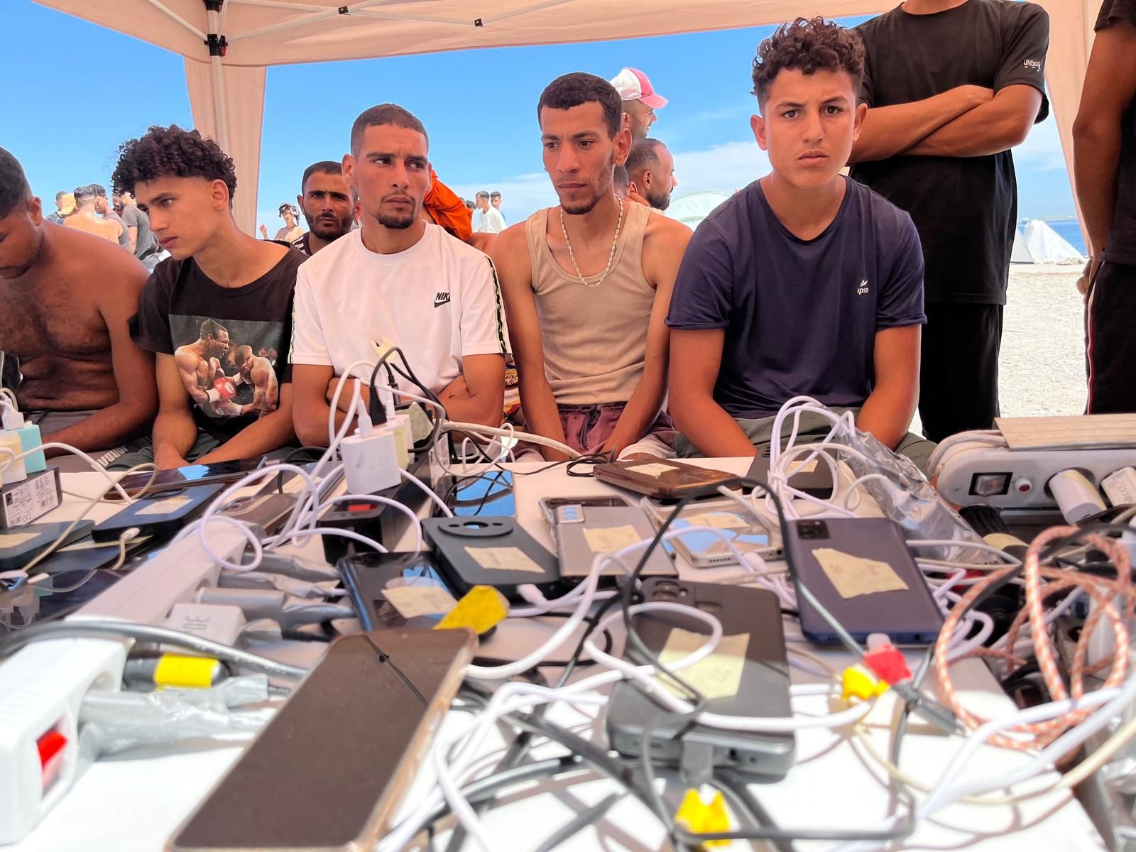 Un voluntario de la ONG alemana supervisa la carga de móviles de los migrantes del Trampolín